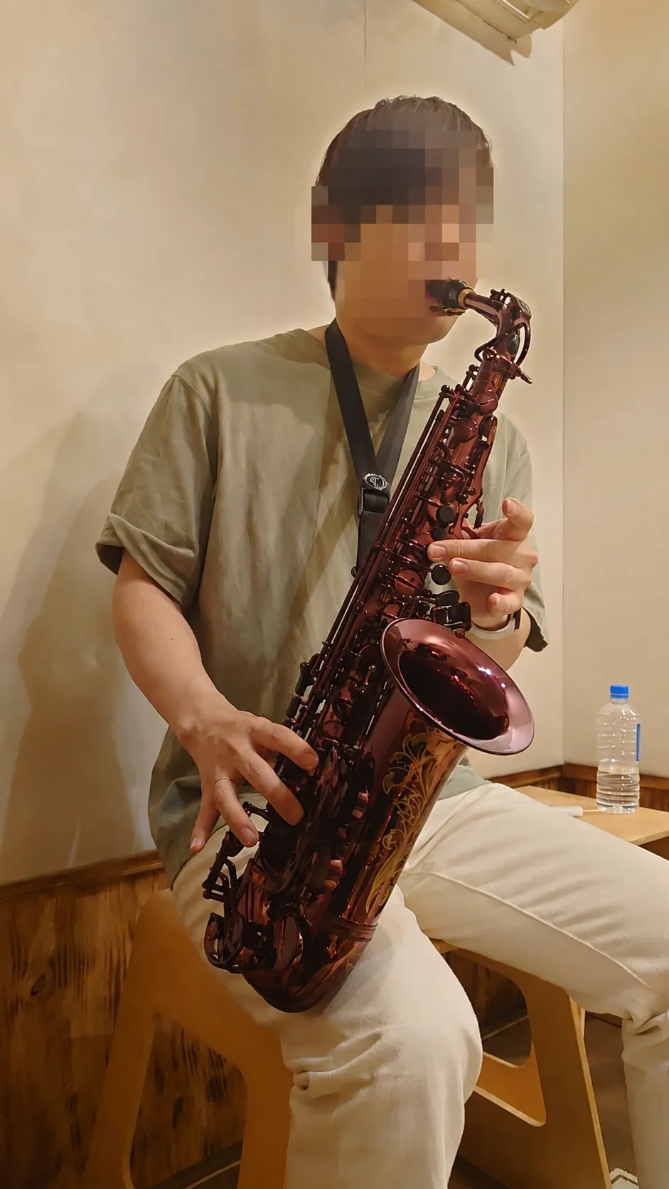 室内でアルトサックスを演奏するKryιk。顔にはモザイクをかけている